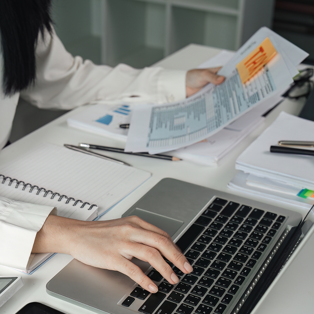 Professional working on a laptop while reviewing tax documents